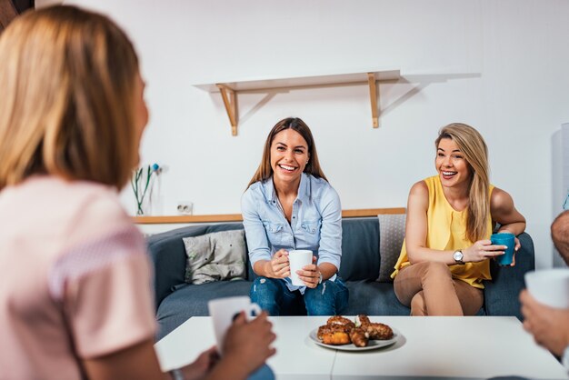 Amigos hablando y divirtiéndose en casa.