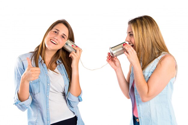 Amigos hablando por un teléfono de estaño sobre fondo blanco