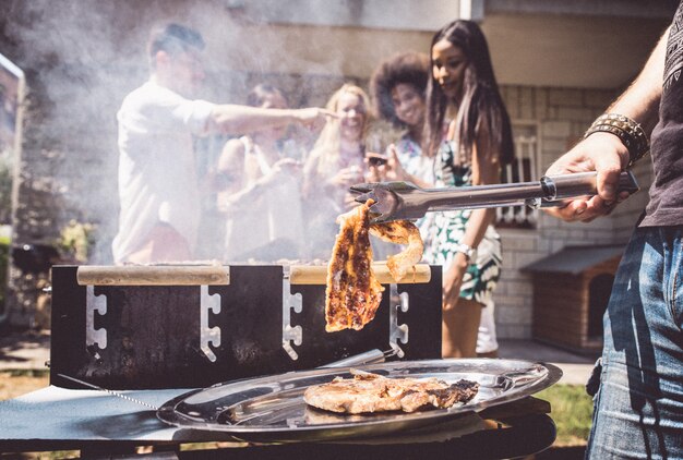 Amigos haciendo barbacoa en el jardín