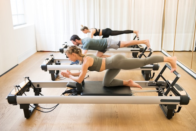 Amigos haciendo ejercicios de pilates de rodillas