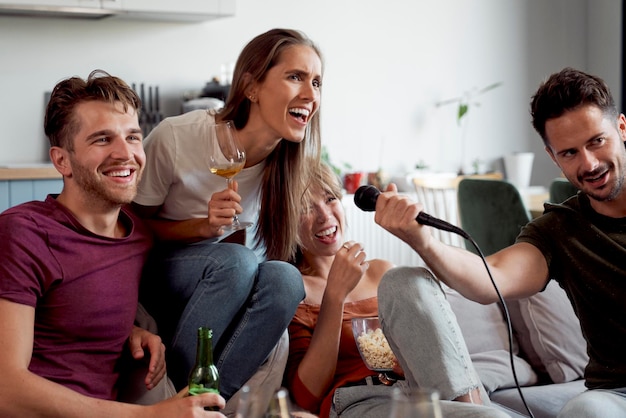 Amigos haciendo karaoke y bebiendo alcohol