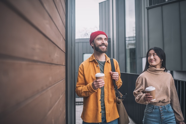 Amigos. Hombre y mujer joven en ropa casual caminando juntos