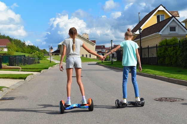 Amigos en hoverboard tomados de la mano en la calle