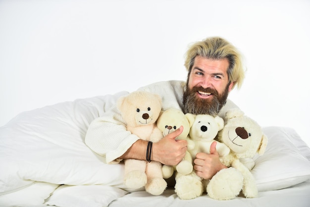 Amigos imaginários Ambiente de quarto positivo Divertido e romântico Brinquedo hipster barbudo Boas vibrações Homem abraça brinquedo macio relaxando na cama Eu não estou sozinho Brinquedo fofo de ursinho de pelúcia Lindo hipster