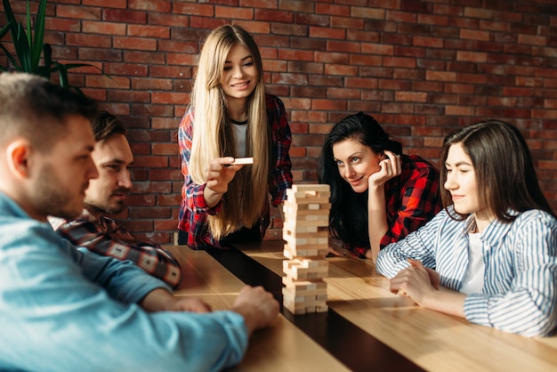 Amigos joga jogo de mesa, foco seletivo na torre