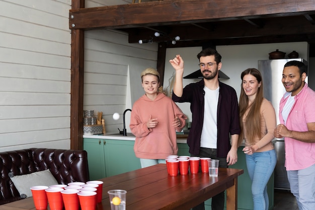 Amigos jogando cerveja pong juntos em uma festa