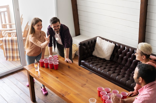 Foto amigos jogando cerveja pong juntos em uma festa