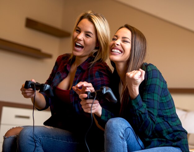 Amigos jogando videogame em casa. diversão em casa.