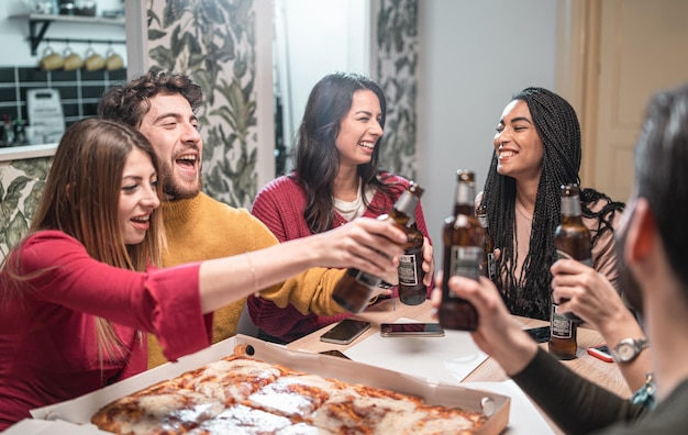 Foto amigos jóvenes brindando en la mesa.