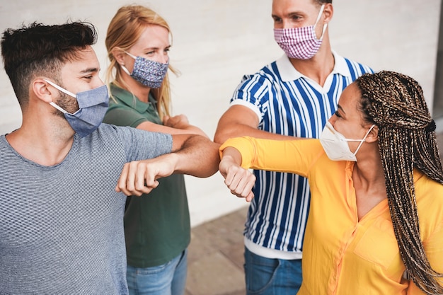 Foto amigos jovens batem os cotovelos em vez de cumprimentá-los com um abraço