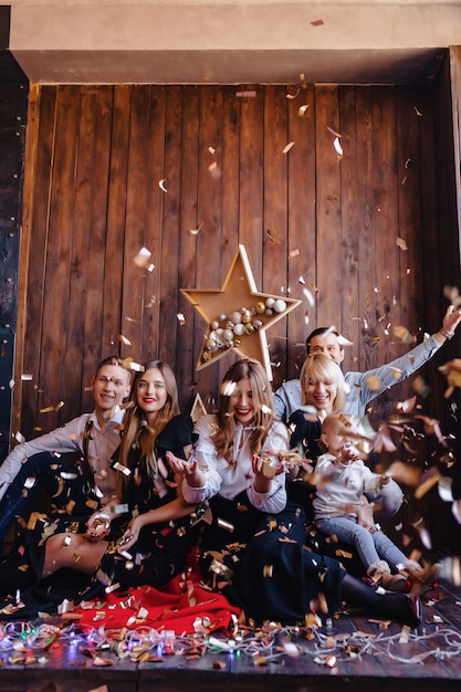 Amigos juegan con confeti en celebración de año nuevo, ambiente de hogar, Navidad