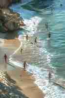 Foto amigos jugando un juego de fútbol americano en una playa de arena en v vecinos actividades de vacaciones de fondo