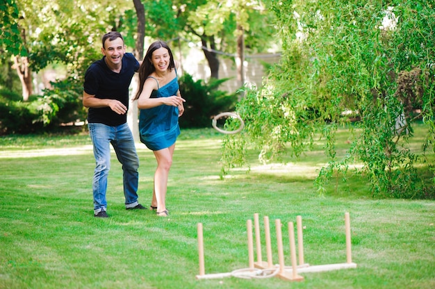 Amigos jugando juegos al aire libre - lanzamiento de anillos en el parque de verano.