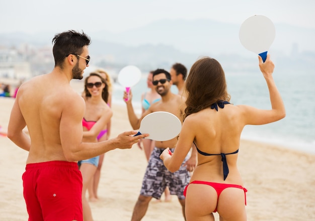 Amigos jugando con raquetas en la playa