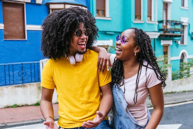 Foto amigos latinos à moda desfrutando de uma discussão animada em um bairro colorido que exala frescura urbana