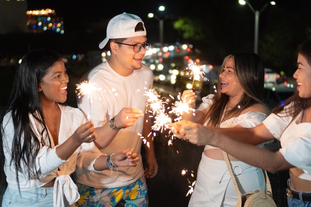 Amigos latinos con bengalas durante la fiesta al aire libre