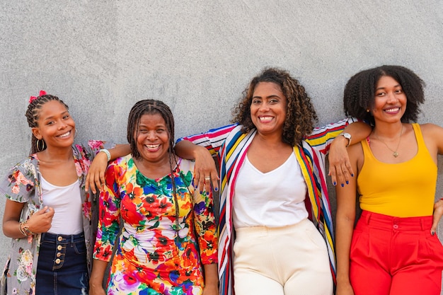 Foto amigos latinos frente a una pared sonriendo a la cámara