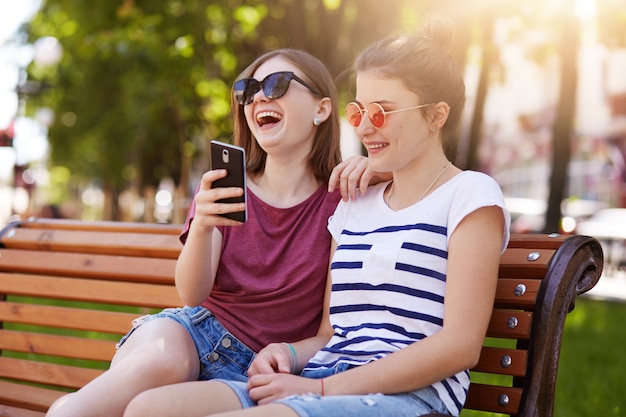 Amigos leais e felizes se sentem bem um no outro no parque.