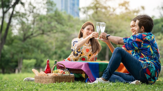 Amigos LGBTQ fazem piquenique Jovens amigos felizes fazendo piquenique no Parque da cidadePessoas saindo sorrindo