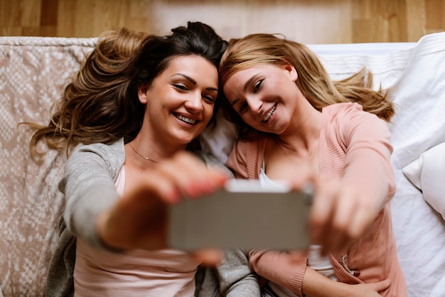 Amigos lindos tirando uma selfie no quarto. Melhor conceito de amigo.