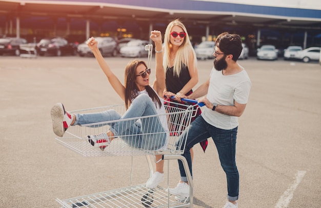 Amigos locos jugando con carrito de compras