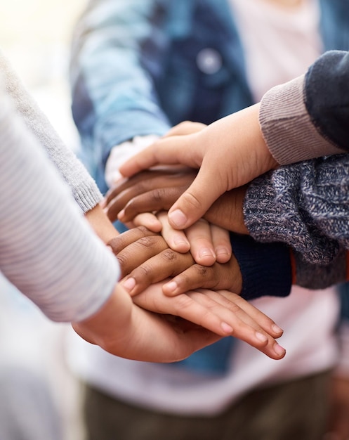 Los amigos se mantienen unidos Foto de un grupo de niños de escuela primaria irreconocibles uniendo sus manos en un grupo