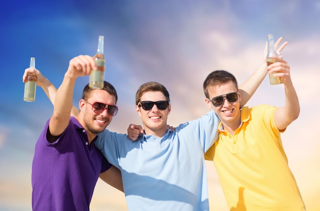 Foto amigos masculinos con botellas de bebida