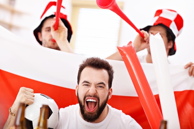 amigos masculinos felizes torcendo e assistindo esportes na tv