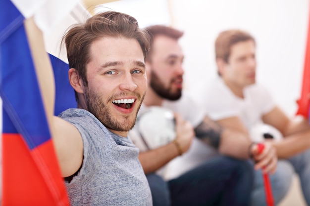 Foto amigos masculinos felizes torcendo e assistindo esportes na tv