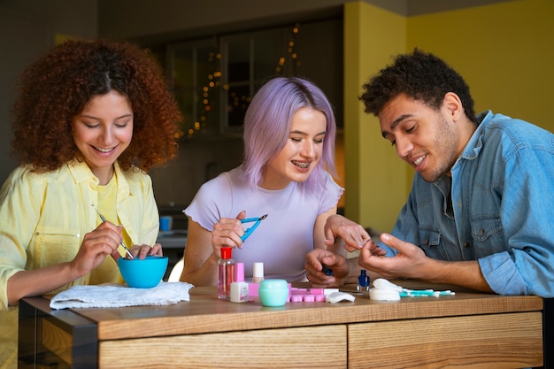 Amigos masculinos y femeninos haciéndose la manicura juntos