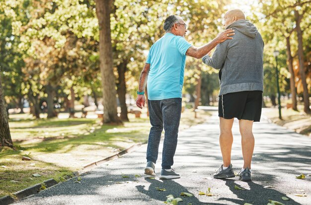 Amigos mayores caminan y hablan en el parque durante la jubilación, fitness y bienestar al aire libre Personas mayores hablando y charlando en la naturaleza, ejercicio y cardio para apoyar la salud en la conversación