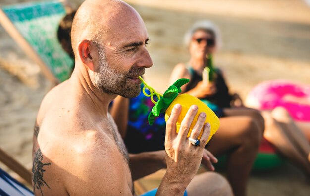 Amigos mayores colgando en la playa