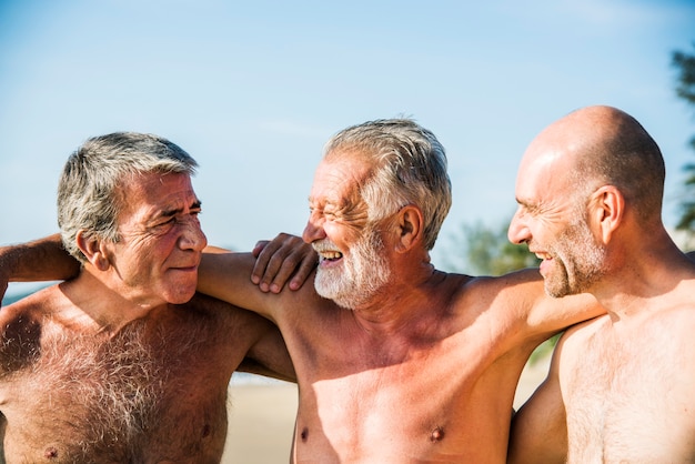 Amigos mayores divirtiéndose en la playa