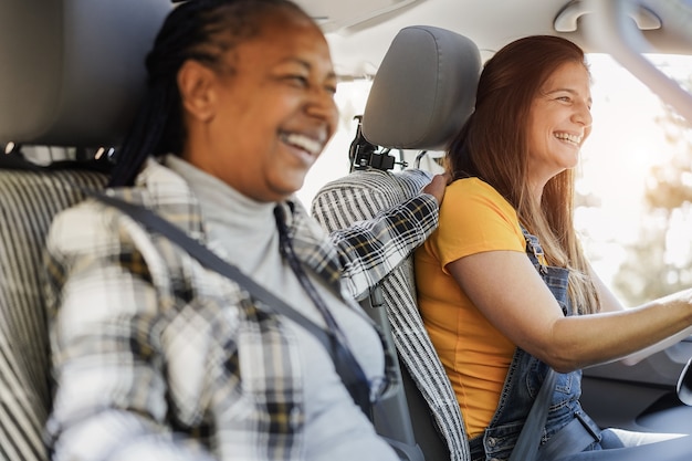 Amigos mayores multirraciales que se divierten en la carretera con mini van camper - Enfoque en el rostro de la mujer derecha