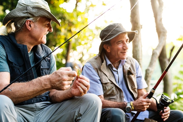 Amigos mayores que pescan en el lago