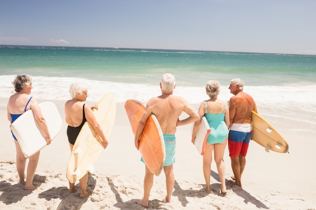 Foto amigos mayores con tabla de surf