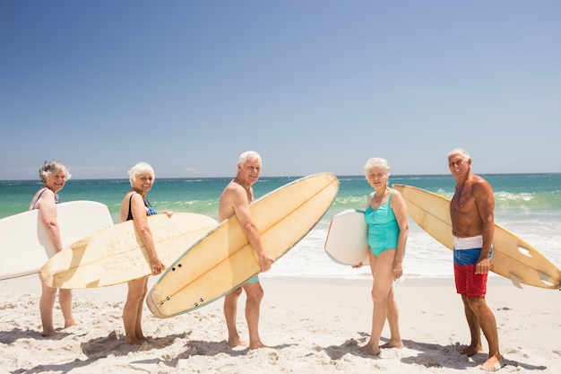 Amigos mayores con tabla de surf