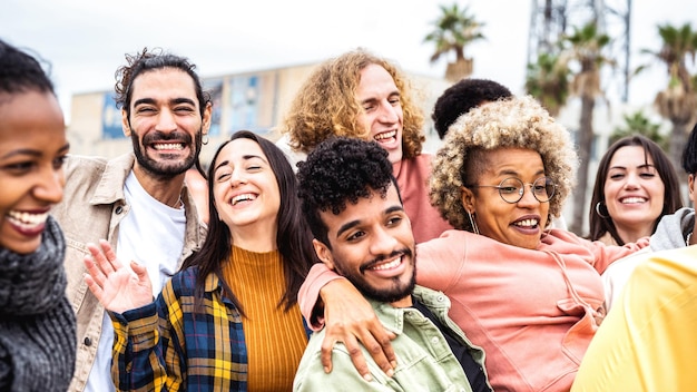 Amigos milenarios animando juntos en el paseo marítimo de la ciudad en el concepto de estilo de vida