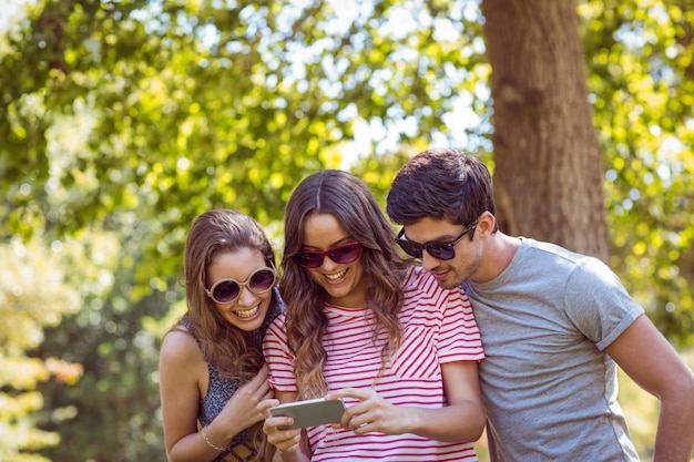 amigos mirando fotos en un parque