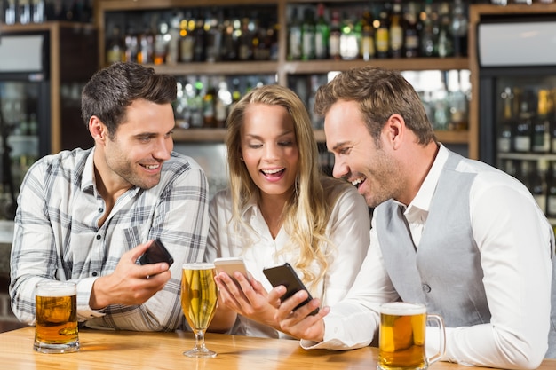 Amigos mirando teléfonos inteligentes