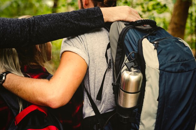 Amigos con mochilas trekking a través de un bosque