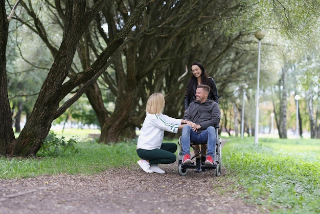 Amigos de mujeres y hombres en silla de ruedas se comunican en rehabilitación de parques y apoyo amistoso
