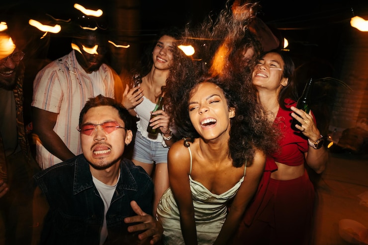Foto amigos multiculturais estão dançando, divertindo-se e bebendo cerveja no clube noturno ao ar livre no telhado418585935