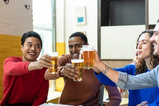 Amigos multiétnicas bebendo cerveja no restaurante bar da cervejaria no fim de semana Conceito de amizade com jovens se divertindo juntos brindando cerveja cerveja no happy hour no pub Foco no homem do Oriente Médio