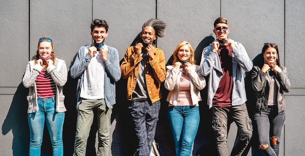 Amigos multirraciais sorrindo com máscara facial após a reabertura do bloqueio