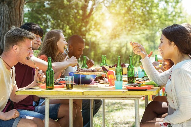 Amigos multirraciales felices haciendo picnic al aire libre