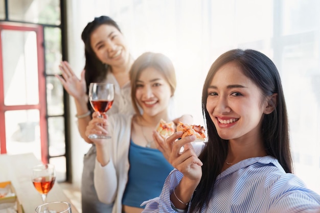 Amigos na festa de aniversário tilintando copos com champanhe e pizza desfrutando de pizza de férias de Natal na mesa Evento de festa de fim de ano