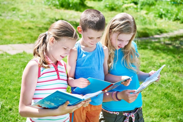 Amigos niños leyendo libros al aire libre