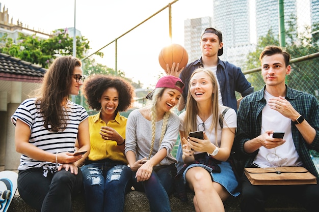 Amigos no parque olhando usando smartphones milenar e conceito de cultura de juventude