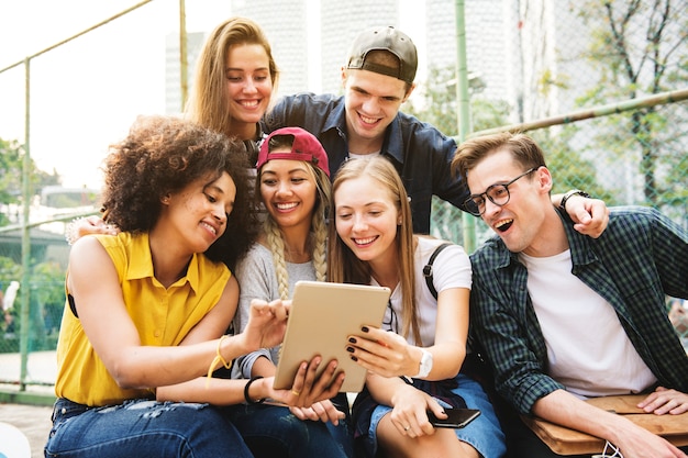 Amigos no parque usando um tablet digital milenar e conceito de cultura de juventude